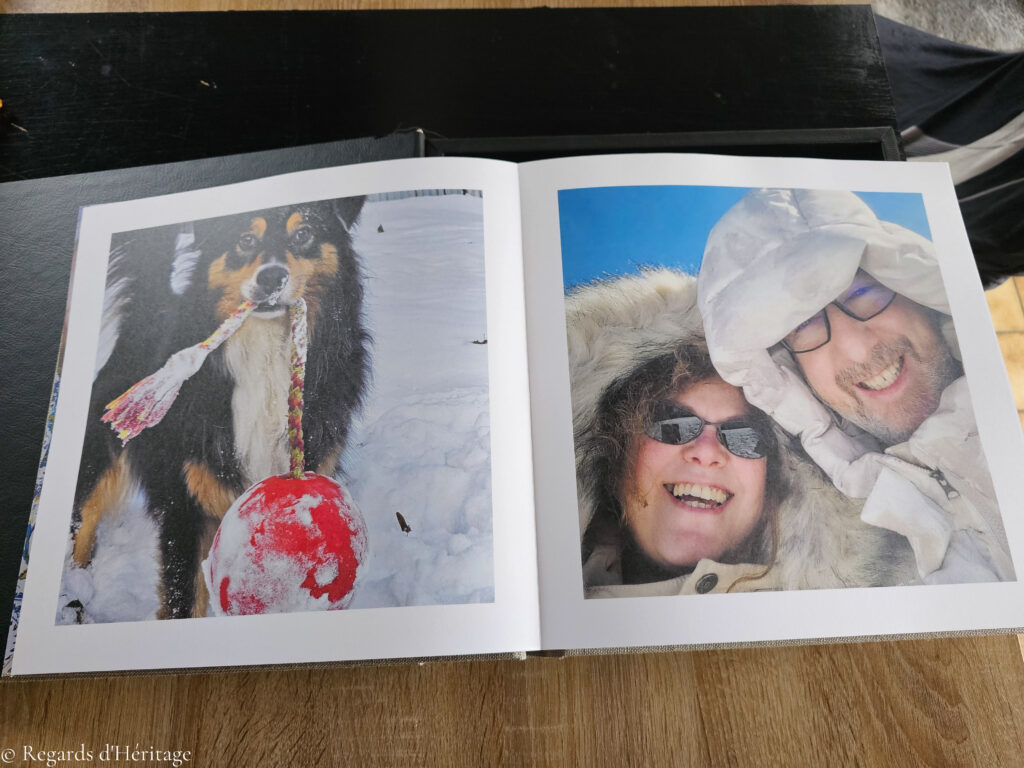 Album Fine Art ouvert sur deux pages : un chien tenant un foulard dans la neige, et un couple souriant en vêtements d’hiver