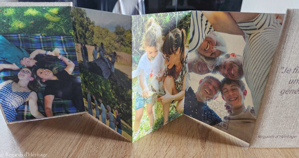 Leporello déplié en frise sur une table en bois, avec des portraits de famille en extérieur : enfants, parents et grands-parent
